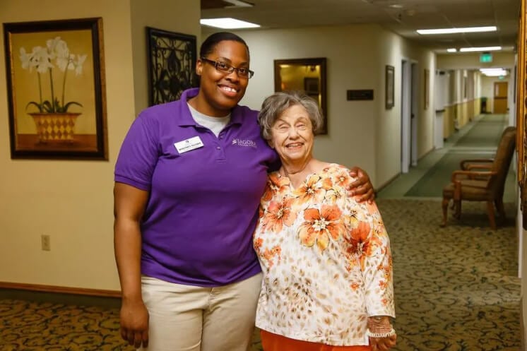 A Senior Woman Standing With a Staff in Burleson Independent Living Facility A Senior Woman Standing With a Staff in Burleson Independent Living Facility